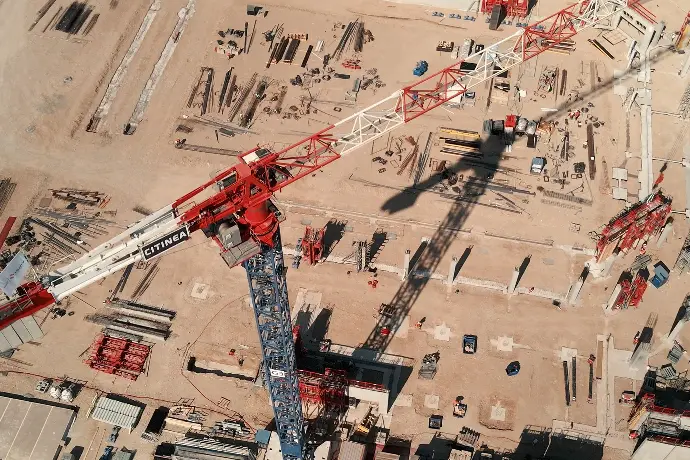 Vue aérienne d'un chantier de construction avec une grue, soulignant l'utilisation des drones pour le suivi de chantiers et la promotion immobilière.